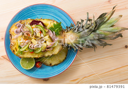Top view of salad with squid, pineapple on wooden background Top view of salad with squid, pineapple on wooden background 81479391