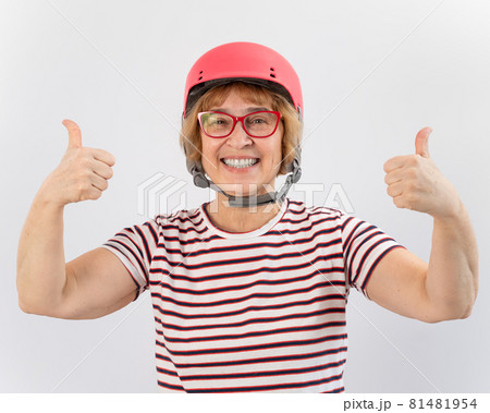 Elderly woman in ski helmet showing thumb up on white background. Elderly woman in ski helmet showing thumb up on white background. 81481954