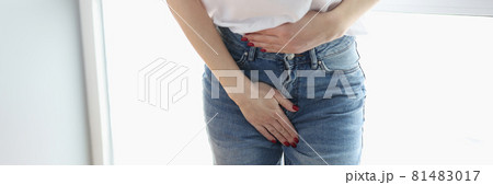 Woman holding her belly and groin area with her hand closeup Woman holding her belly and groin area with her hand closeup 81483017