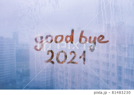lettering good bye and numbers 2021 paint with finger with streaks of water on splashed by rain foggy glass on blue window lettering good bye and numbers 2021 paint with finger with streaks of water on splashed by rain foggy glass on blue window 81483230
