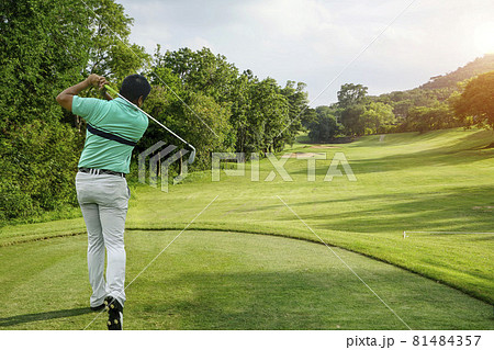 Golfer playing golf in the evening golf course on sun set evening time. 81484357