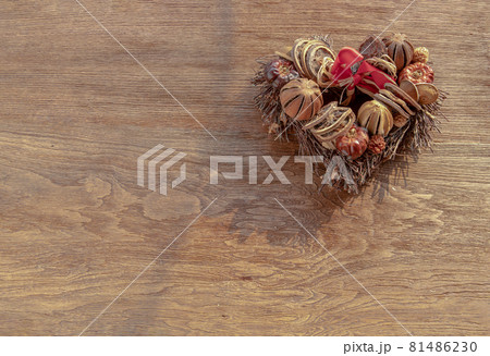 Different dry fruits over on twigs pile shape of heart on wooden background. 81486230