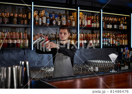 barman is making cocktail with steel shaker 81486476