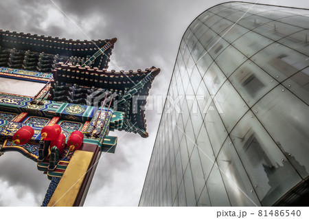Contrast of modern glass building with Chinatown entrance gate in traditional chinese design. 81486540