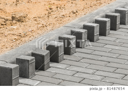 Laying floor tile sidewalk urban road or repairing paving stone slabs at a construction site 81487654