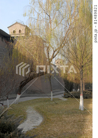 Pingyao in Shanxi Province, China. Pingyao city wall and watchtowers seen through willow trees from the park next to the old wall. Pingyao in Shanxi Province, China. Pingyao city wall and watchtowers seen through willow trees from the park next to the old wall. 81489821