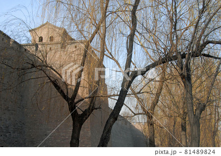 Pingyao in Shanxi Province, China. Pingyao city wall and watchtowers seen through trees from the park next to the old wall. Pingyao in Shanxi Province, China. Pingyao city wall and watchtowers seen through trees from the park next to the old wall. 81489824