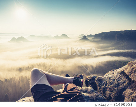 Resting man. Traveler\'s naked legs pointed towards to mountain peak 81490953