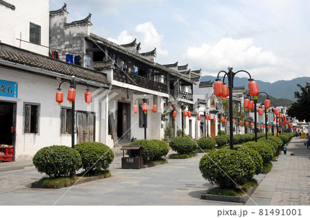 Jiangwan in Wuyuan County, Jiangxi Province, China. Jiangwan is an ancient town in Wuyuan County known for its Tang Dynasty architecture. Wide street with red lanterns and green bushes. Jiangwan in Wuyuan County, Jiangxi Province, China. Jiangwan is an ancient town in Wuyuan County known for its Tang Dynasty architecture. Wide street with red lanterns and green bushes. 81491001