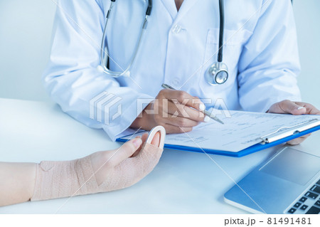 Doctors hand holding pen and report health examination results, recommend medication to patients in arm accident 81491481