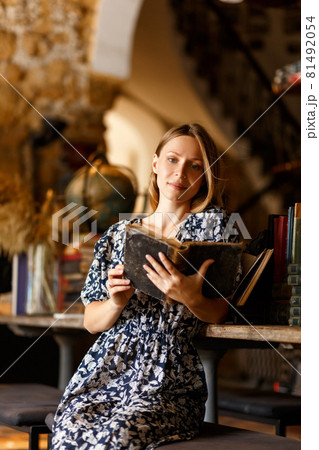 Girl holding book.People, knowledge, education and school concept - happy student girl or young woman with book posing in an old library. Girl holding book.People, knowledge, education and school concept - happy student girl or young woman with book posing in an old library. 81492054