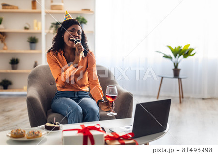 Black Woman At Laptop Singing Karaoke Celebrating B-Day Online Indoors 81493998