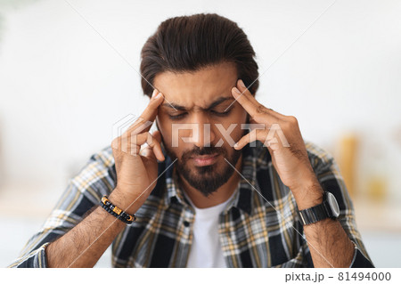 Closeup portrait of tired arab man suffering from headache 81494000