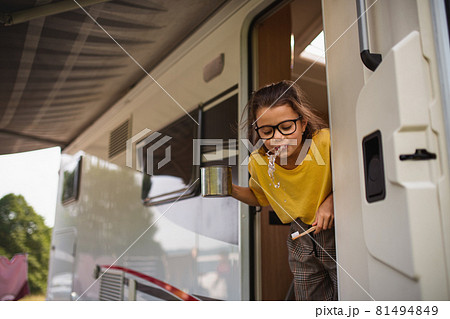 Happy small girl brushing teeth by caravan, family holiday trip. Happy small girl brushing teeth by caravan, family holiday trip. 81494849