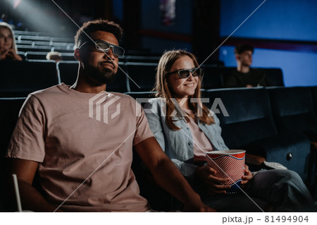 Cheerful young couple with 3d glasses in the cinema, watching film. 81494904