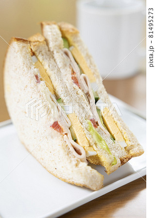 美味しいソーセージと玉子と野菜の全粒粉サンドイッチとコーヒー 81495273