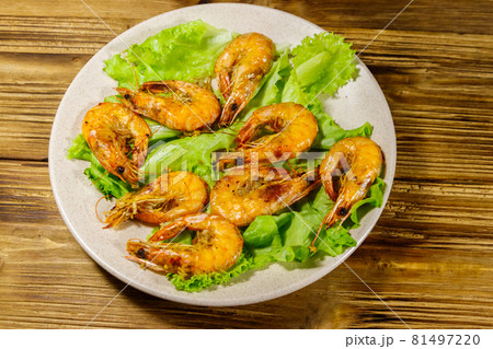 Tasty baked shrimps on a wooden table 81497220