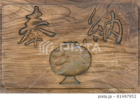 [東京・駒込] 打出の小槌の木彫りと奉納の漢字が書かれたひび割れ板のクローズアップ。 81497952