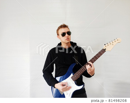 サングラスをかけてギターを弾いているギタリスト男性の写真素材