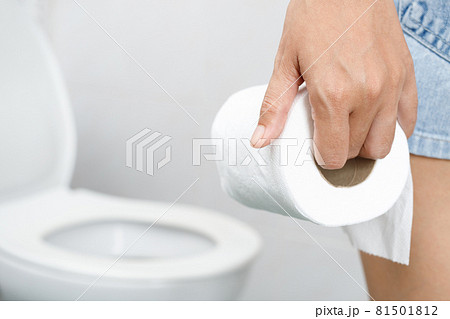 portrait of a woman suffers from diarrhea his stomach painful. ache and problem. hand hold tissue paper roll in front of toilet bowl. constipation in bathroom. Hygiene, health care concept. 81501812