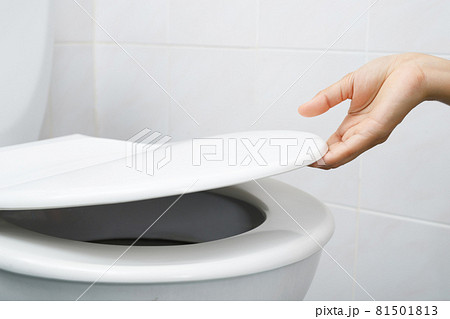 Woman's hand opening the toilet lid 81501813