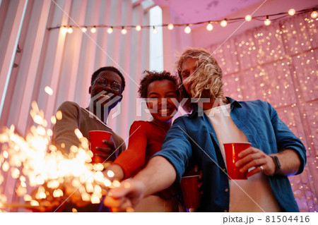 Friends Holding Lights at Party 81504416