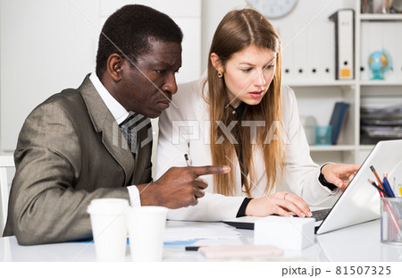 Focused coworkers working together Focused coworkers working together 81507325