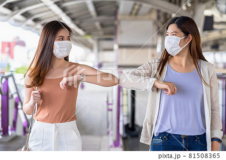 Young Asian woman passenger wearing surgical mask and elbows bump with friend together in subway train when traveling in big city at Covid19 outbreak, Infection and Pandemic, new normal concept 81508365