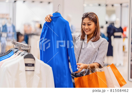 Happy Asian woman choosing clothes in glass store shop with happy action at department center, shopping and shopaholic, lifestyle fashion and leisure, sales and black friday concept 81508462