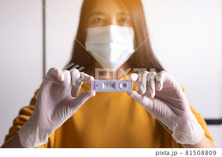 Patient women hands showing result a covid-19 self test rapid antigen testing at home Patient women hands showing result a covid-19 self test rapid antigen testing at home 81508809