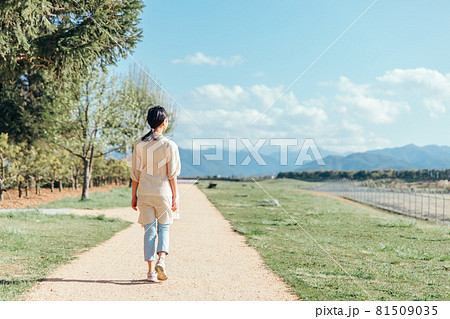 道を歩く小学生の女の子 後ろ姿 全身 の写真素材