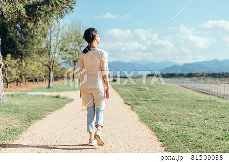 道を歩く小学生の女の子 後ろ姿 全身 の写真素材