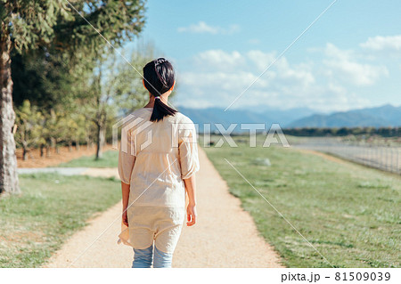 道を歩く小学生の女の子 後ろ姿 上半身 の写真素材