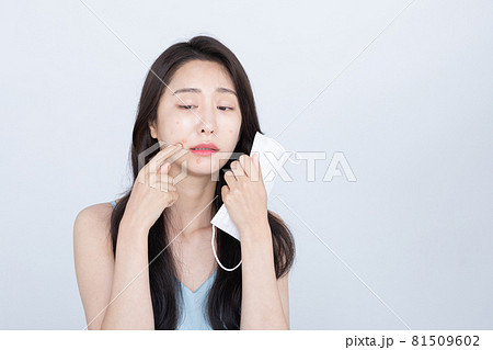 beautiful Asian woman with acne, pimple skin troubles due to wearing mask in covid era 81509602