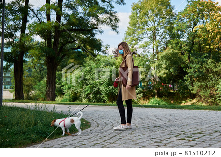 Woman walks with dog 81510212