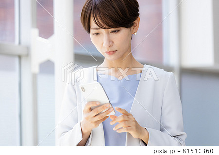 手に持ったスマホを見てネガティブな表情を見せる女性 81510360