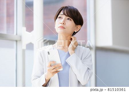 手に持ったスマホを見てネガティブな表情を見せる女性 手に持ったスマホを見てネガティブな表情を見せる女性 81510361