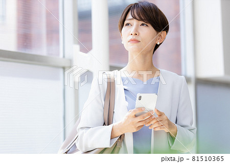 手に持ったスマホを見てネガティブな表情を見せる女性 81510365