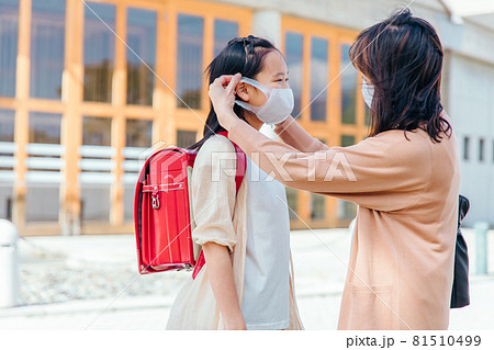 母親にマスクをかけてもらう娘 母親にマスクをかけてもらう娘 81510499