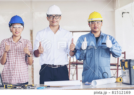 Construction engineer teamwork Safety Suit Trust Team Holding White Yellow Safety hard hat Security Equipment on Construction Site. Hardhat Protect Head for Civil Construction Engineer Concept 81512169