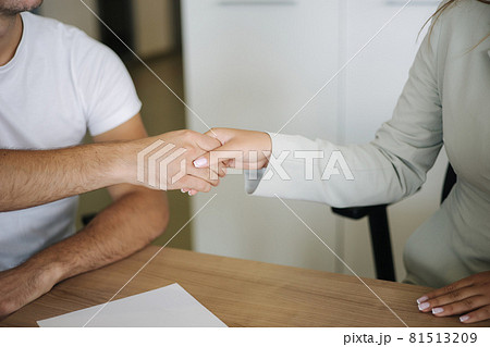 Close up of salesman and customer shake hands after successful sale in car showroom 81513209