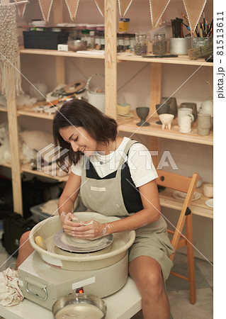 Happy woman crafting pottery in workshop 81513611