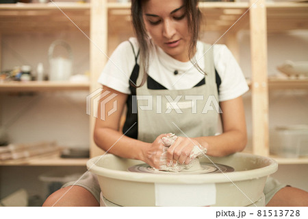Craftswoman creating earthenware on wheel 81513728