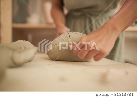 Unrecognizable female artisan dividing clay Unrecognizable female artisan dividing clay 81513731