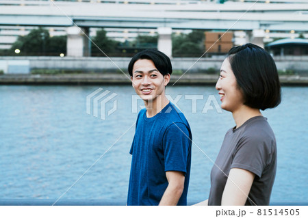 川沿いで会話する男女 81514505