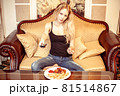 Beautiful young adult blond woman watching TV set Beautiful young adult blond woman watching TV set 81514867