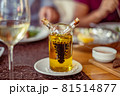Glass on a high thin leg with white wine in a Glass on a high thin leg with white wine in a 81514877