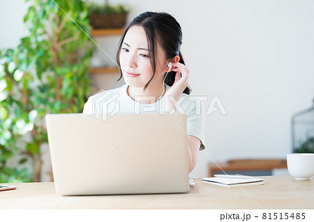 イヤホンに手を当てて会話を聞き取る女性 81515485