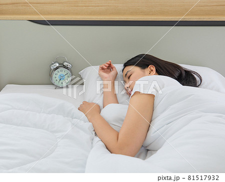 Youn and beautiful black long hair Asian woman deeply sleeping on bed in bedroom bedside alarm clock 81517932