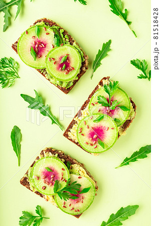 Toasts with watemelon radish, avocado and flex seeds Toasts with watemelon radish, avocado and flex seeds 81518428
